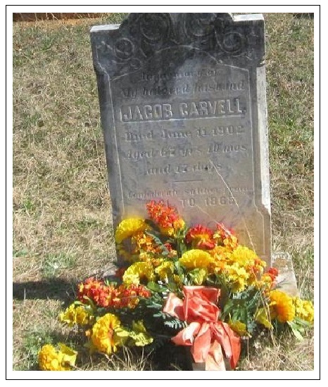 Grave marker of Jacob Carvell, decorated with flowers